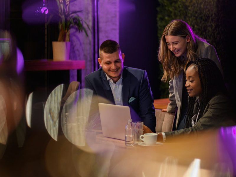 cheerful-work-colleagues-working-on-a-laptop-while-having-a-meeting-in-a-cafe.jpg