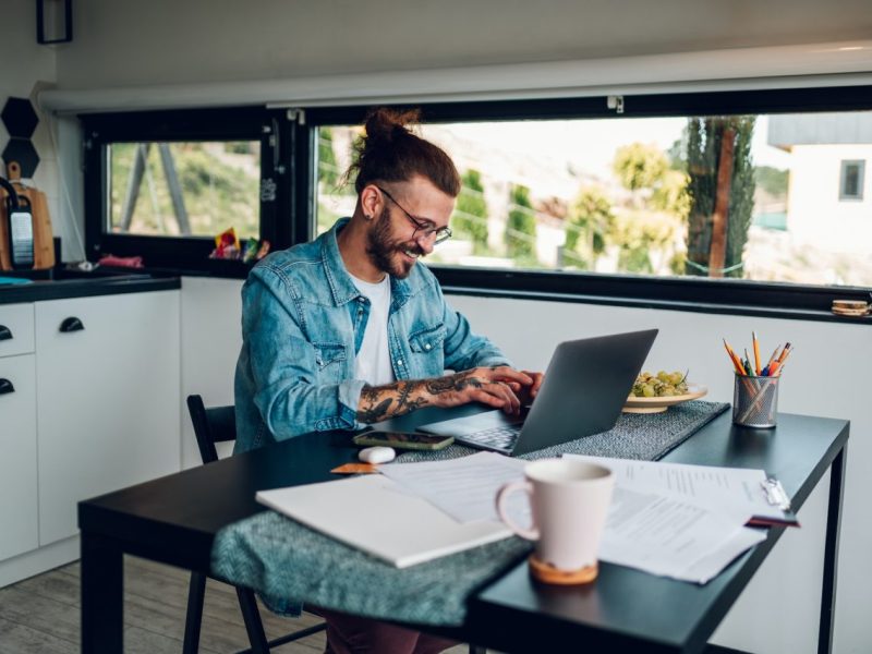 young-business-man-working-at-home-with-laptop-and-papers-on-desk.jpg